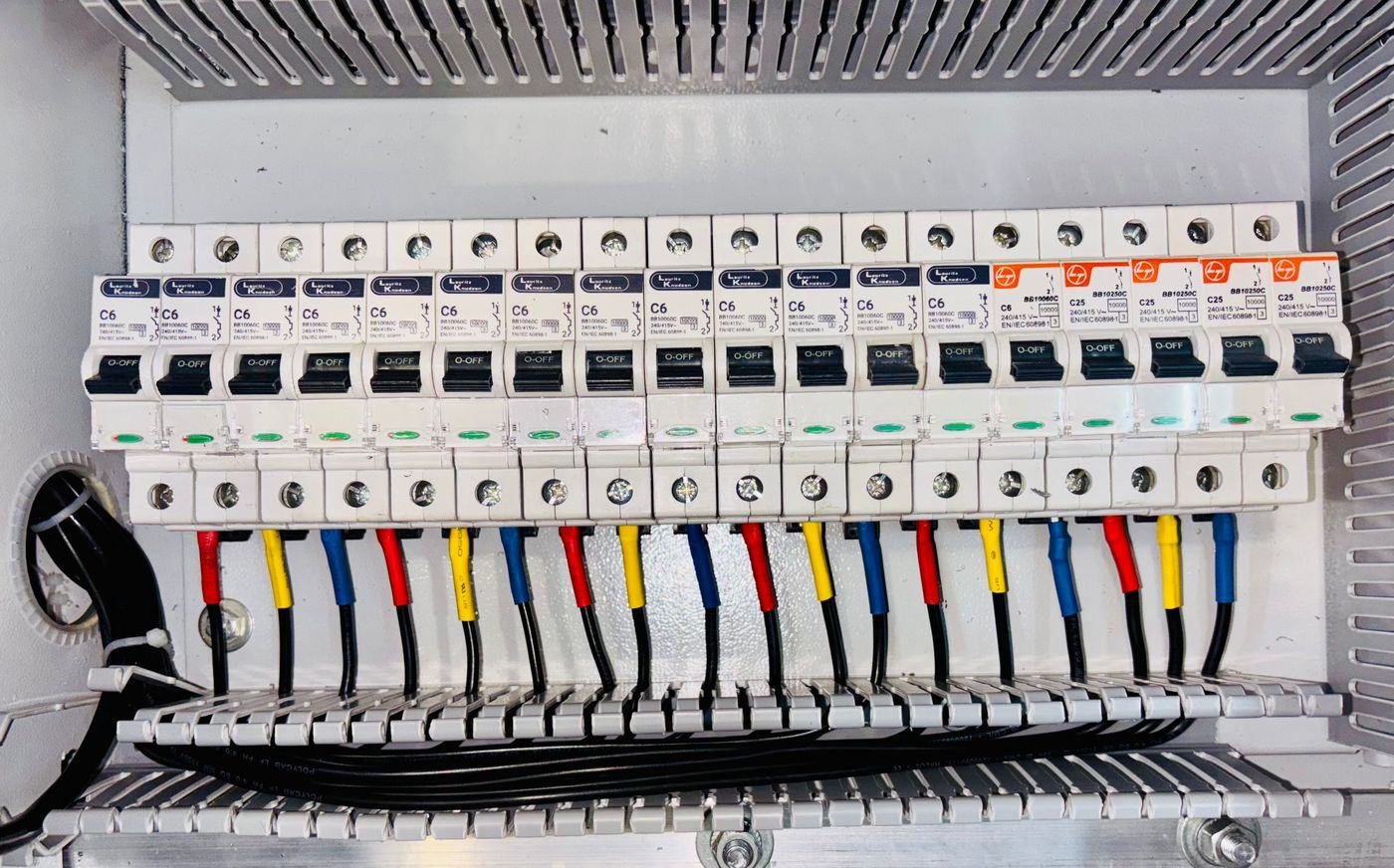 Row of MCBs with colour-coded wires in a distribution board