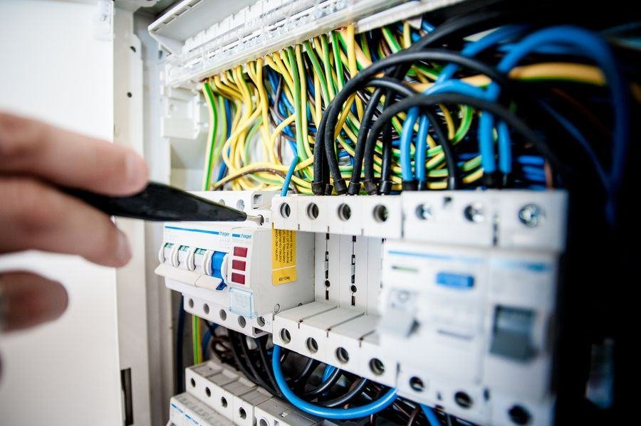 Electrician working on a panel full of MCBs and wires