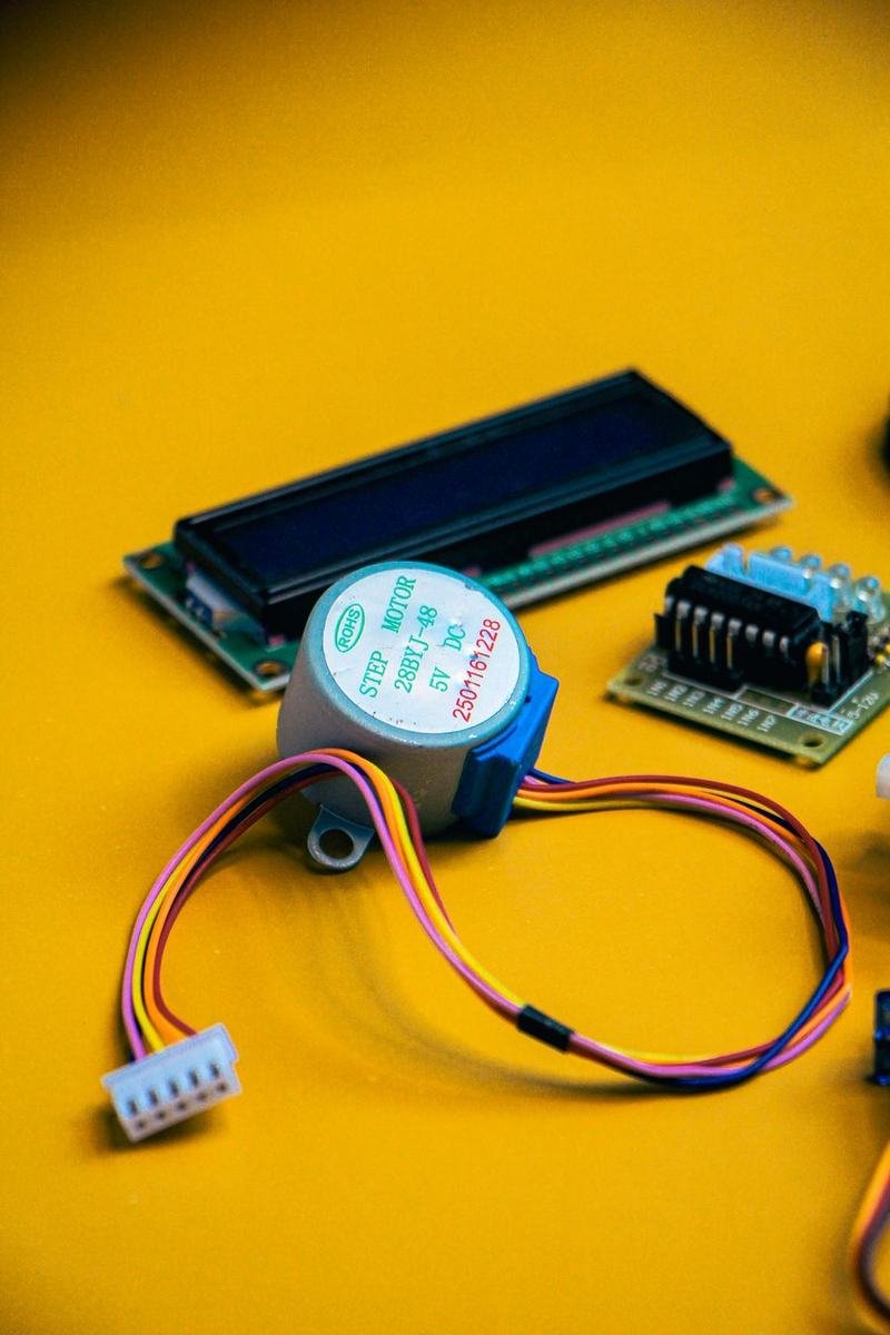 Stepper motor with driver board and cable on a yellow background